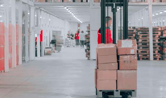 Employee transports products in a large warehouse after its packing