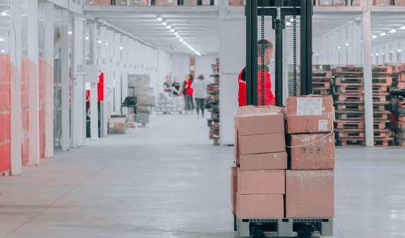 Operario de un almacén realiza el picking en un transportador.