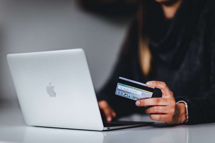 Chica utiliza la tarjeta de crédito como método de pago para realizar una compra online.