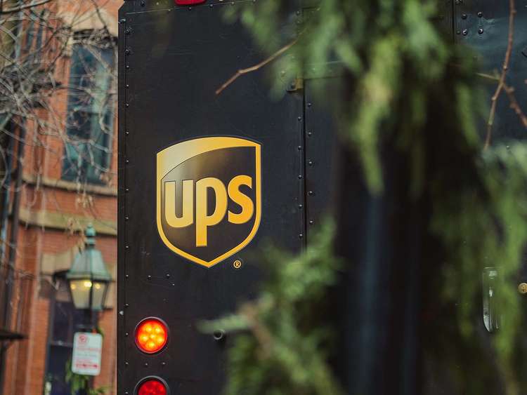 Poradnik wysyłkowy UPS dla sklepów online, osoby na zdjęciu przekazują sobie przesyłki od tego kuriera